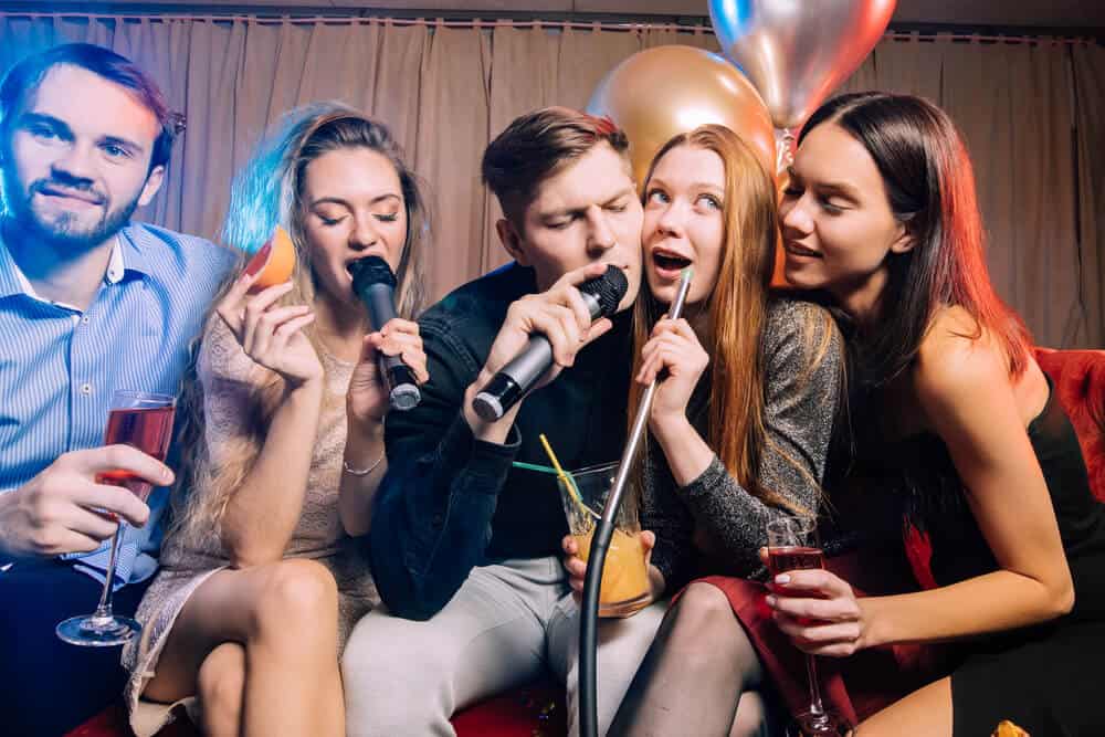 Group of young friends in karaoke bar
